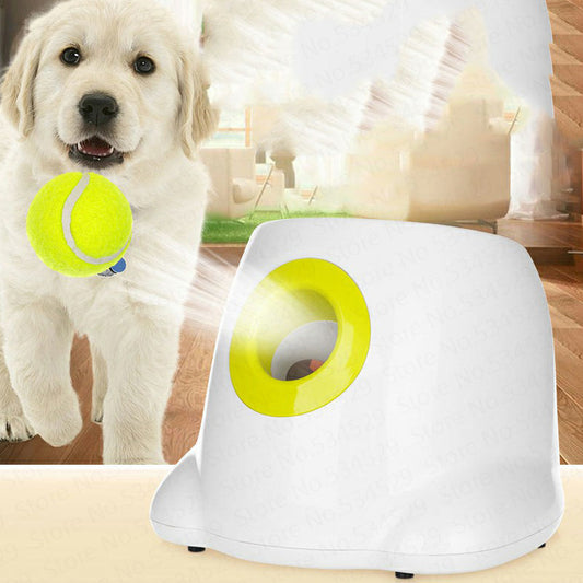 Orange Poppy automatic dog ball launcher white with yellow rim beside golden retriever puppy holding tennis ball in living room