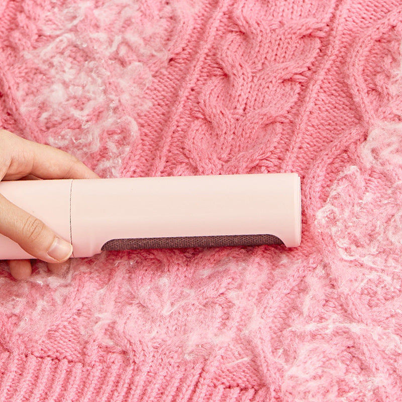 Orange Poppy reusable pet hair remover brush removing white pet fur from pink cable knit blanket