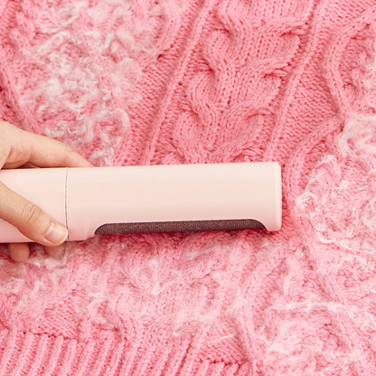 Orange Poppy reusable pet hair remover brush removing white pet fur from pink cable knit blanket