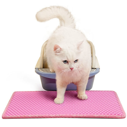 Pink easy clean litter mat for cats placed in front of a litter box with a white cat exiting