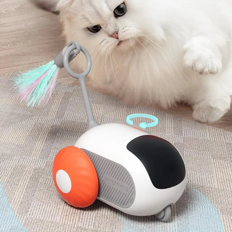 Orange Poppy remote control cat toy white rolling robot with orange wheels and feather wand on rug