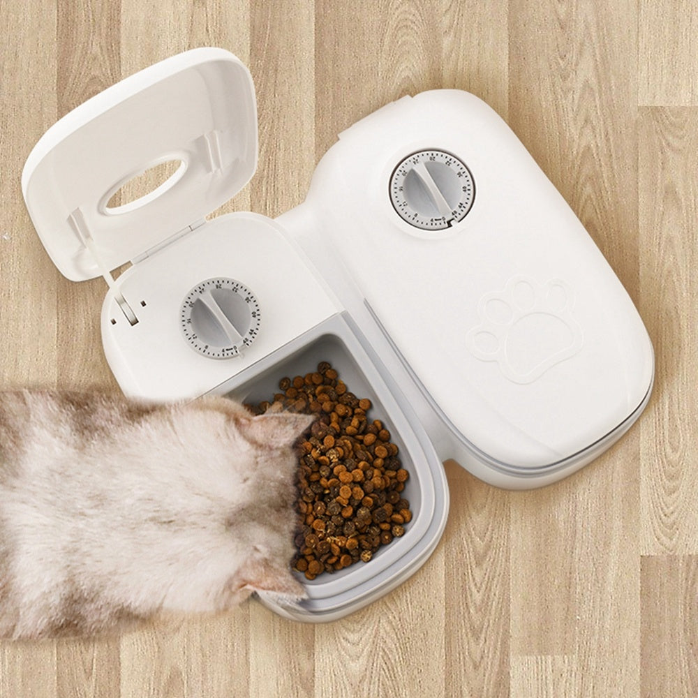 White smart pet food dispenser for cats and dogs with dual timers open showing cat eating dry kibble