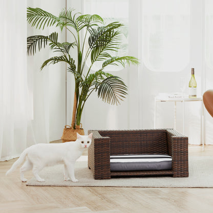 Ochre Menoetius rattan dog bed with cushion in a modern living room setting with white cat nearby
