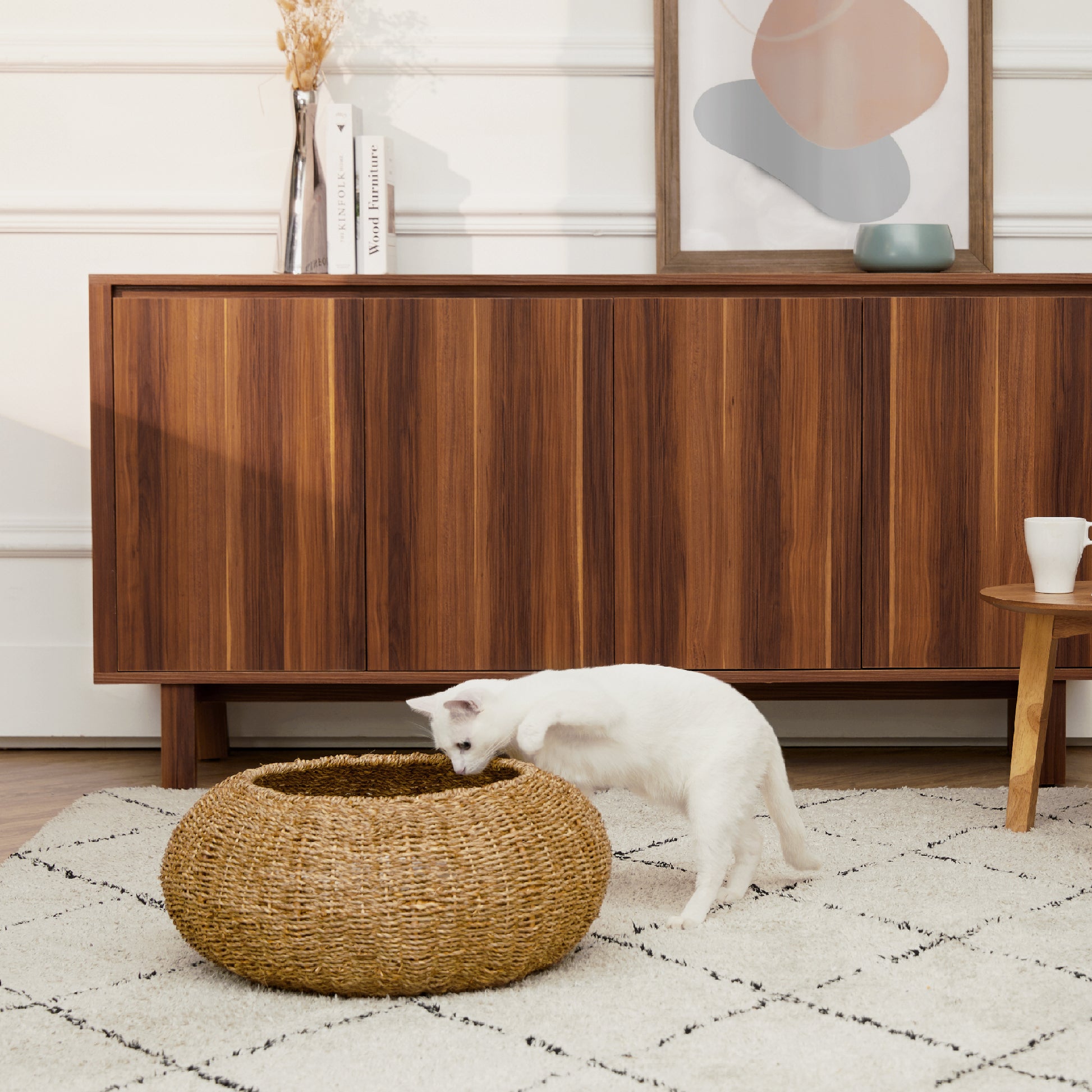 Ochre Menoetius woven pet bed for cats and dogs with natural fiber design and a white cat exploring it