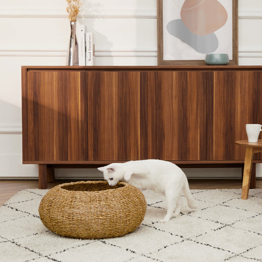 Ochre Menoetius woven pet bed for cats and dogs with natural fiber design and a white cat exploring it