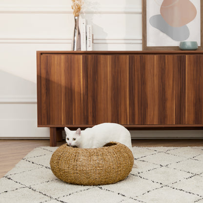 Woven pet bed for cats and dogs by Ochre Menoetius with a white cat resting inside on a patterned rug